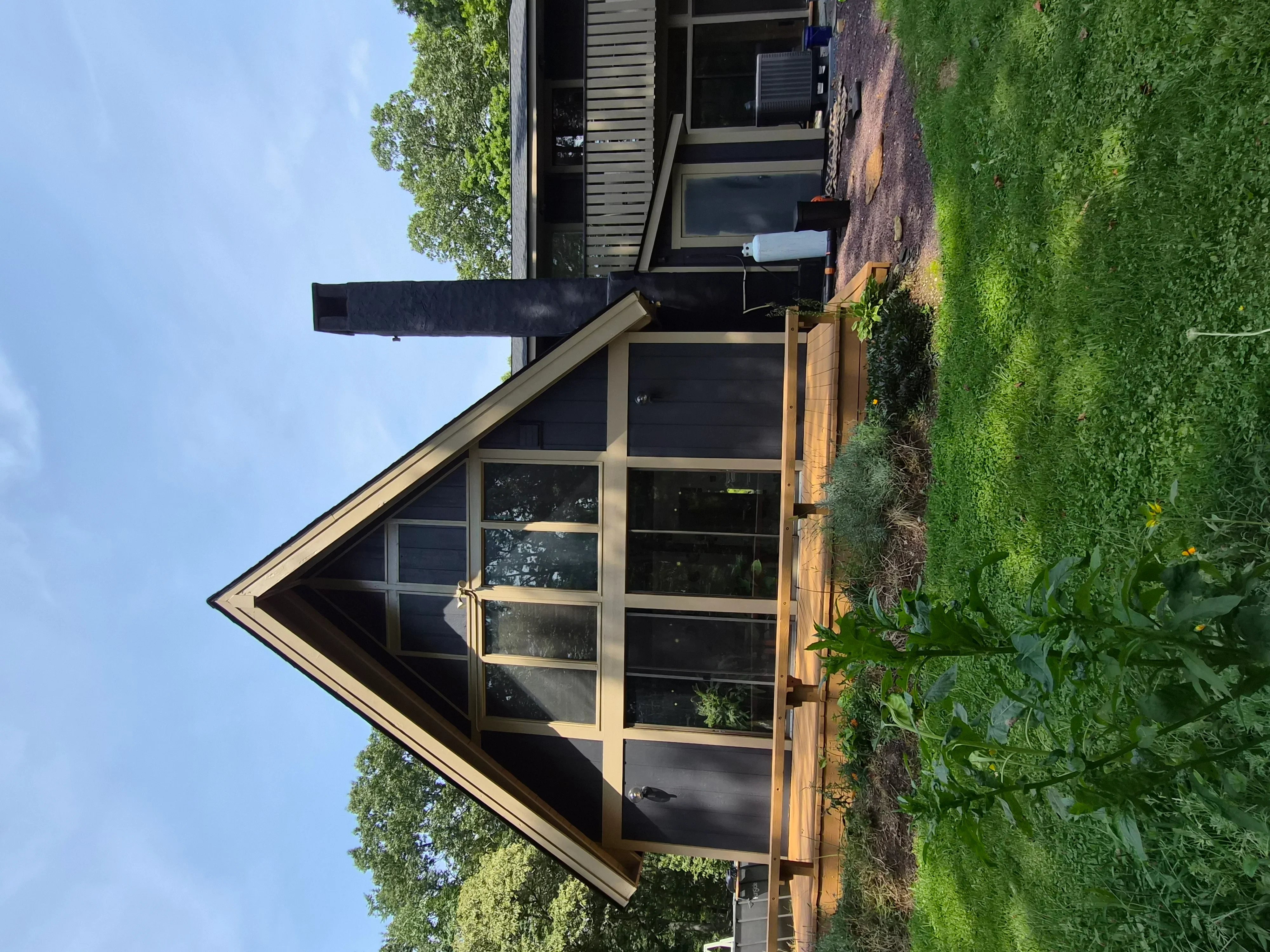 Dark painted house exterior with cream trim, multi-pane windows, and detailed woodwork
