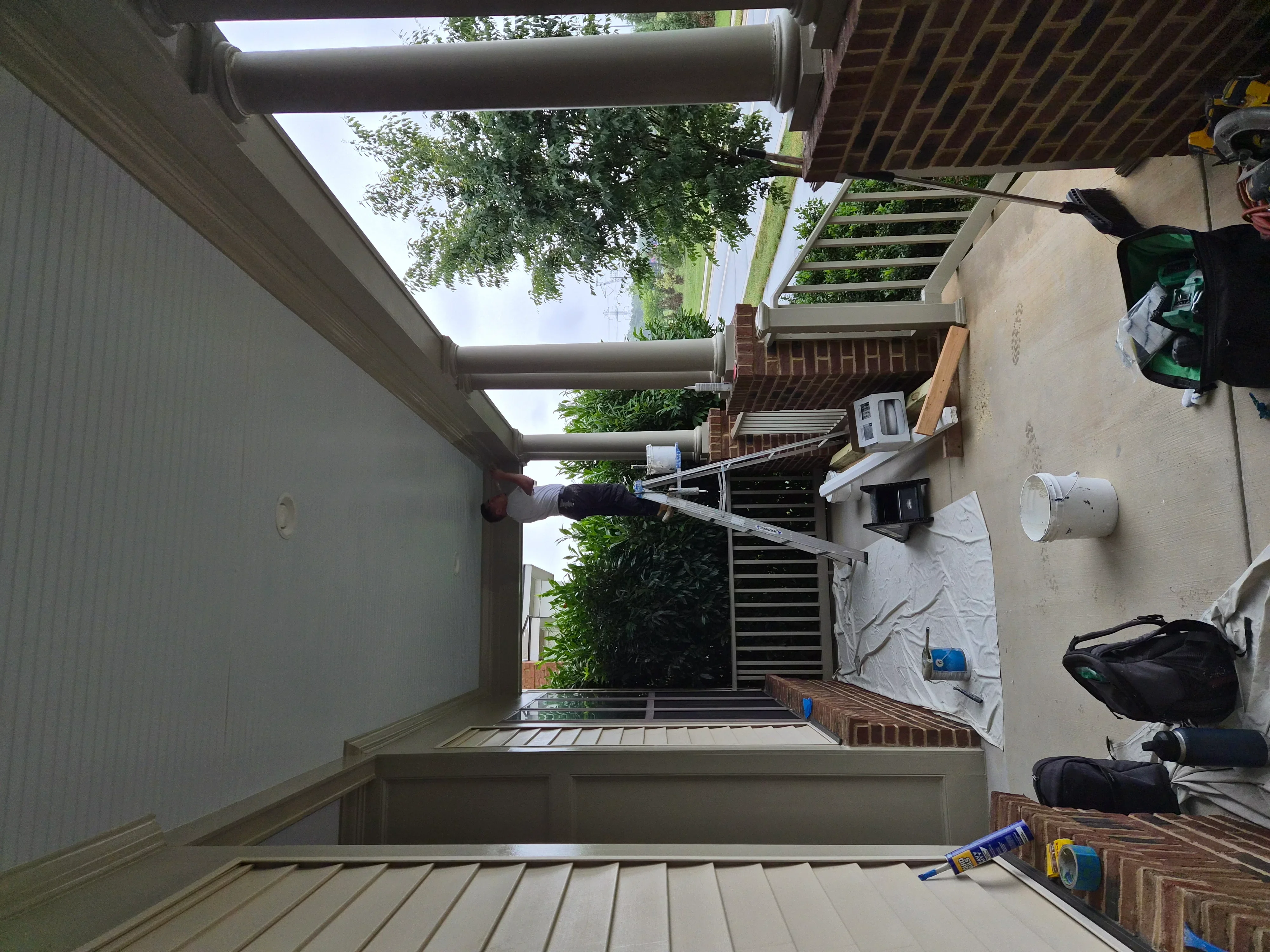 Newly painted gray deck boards with stained wood railings and trim on residential patio