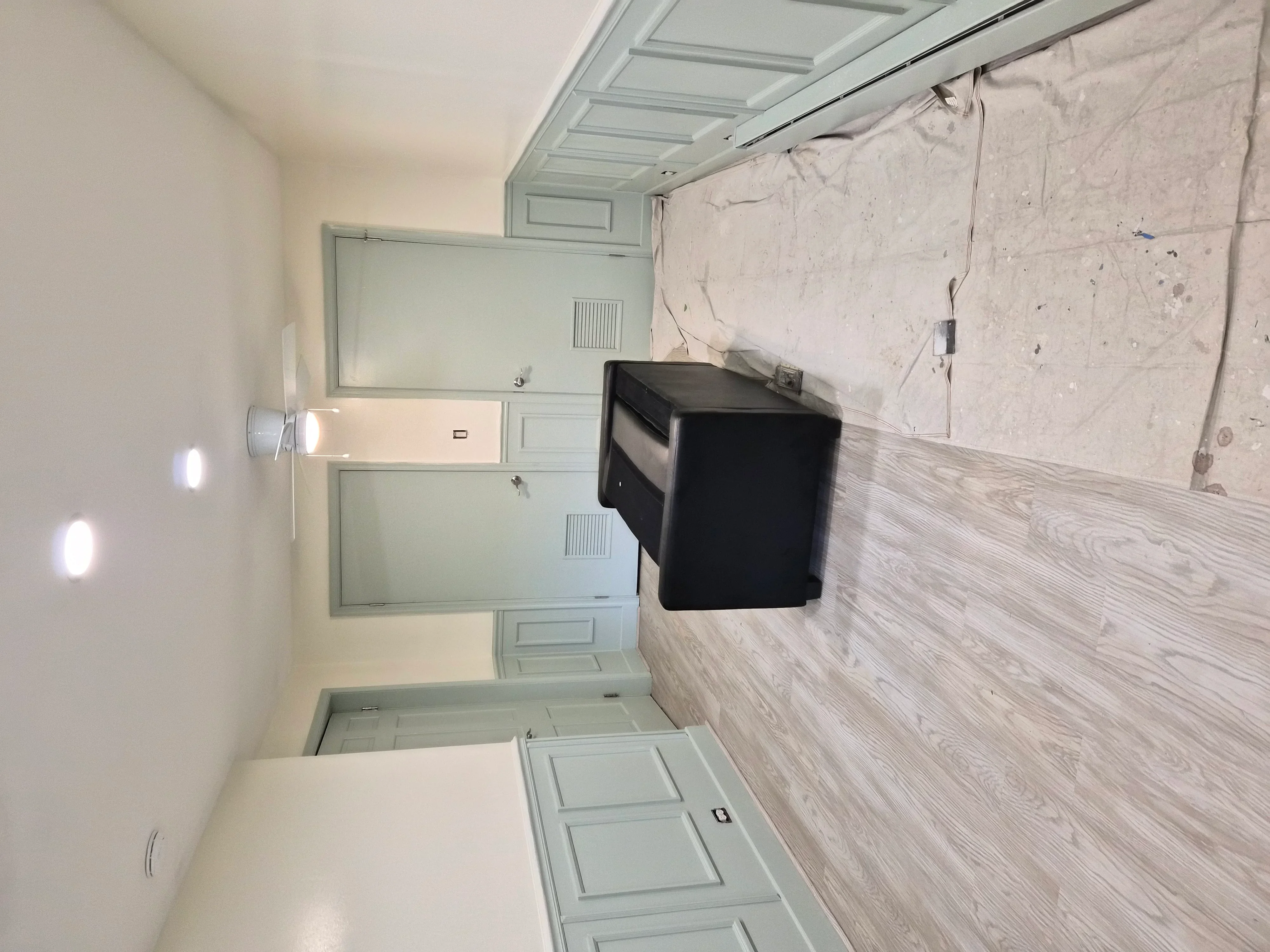 Bathroom with painted blue cabinetry, white walls, coffered ceiling, and wood-look vinyl flooring