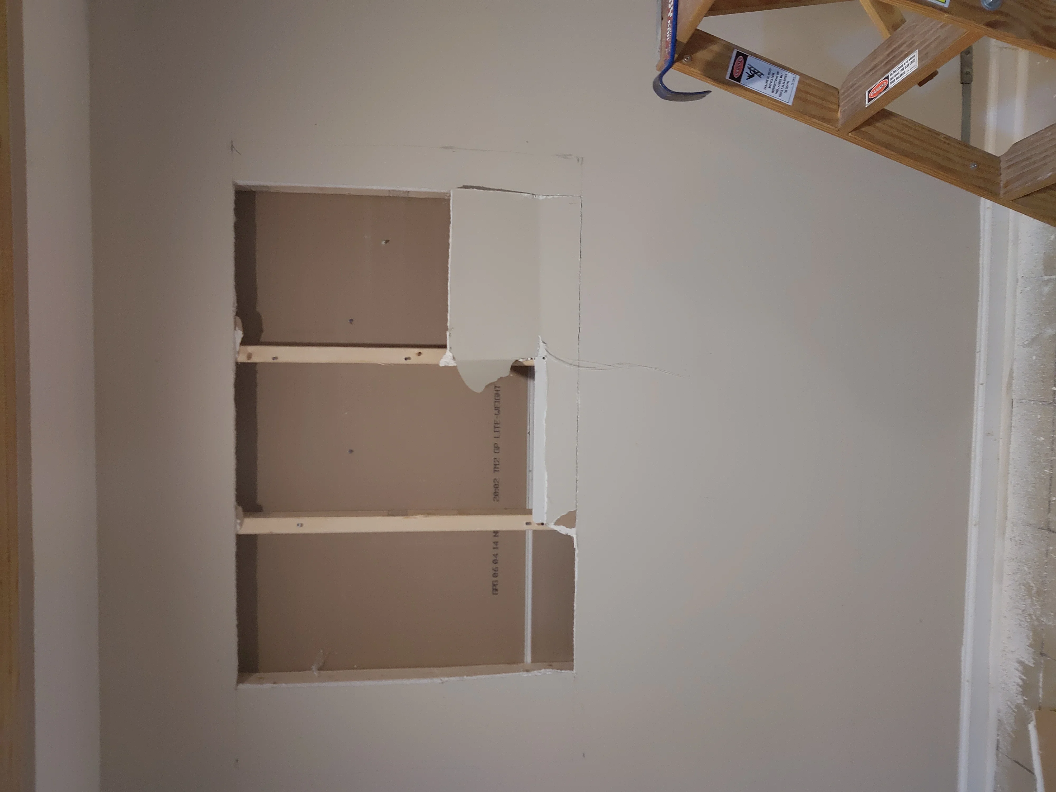 Drywall installation with horizontal shelving cutouts and taped seams