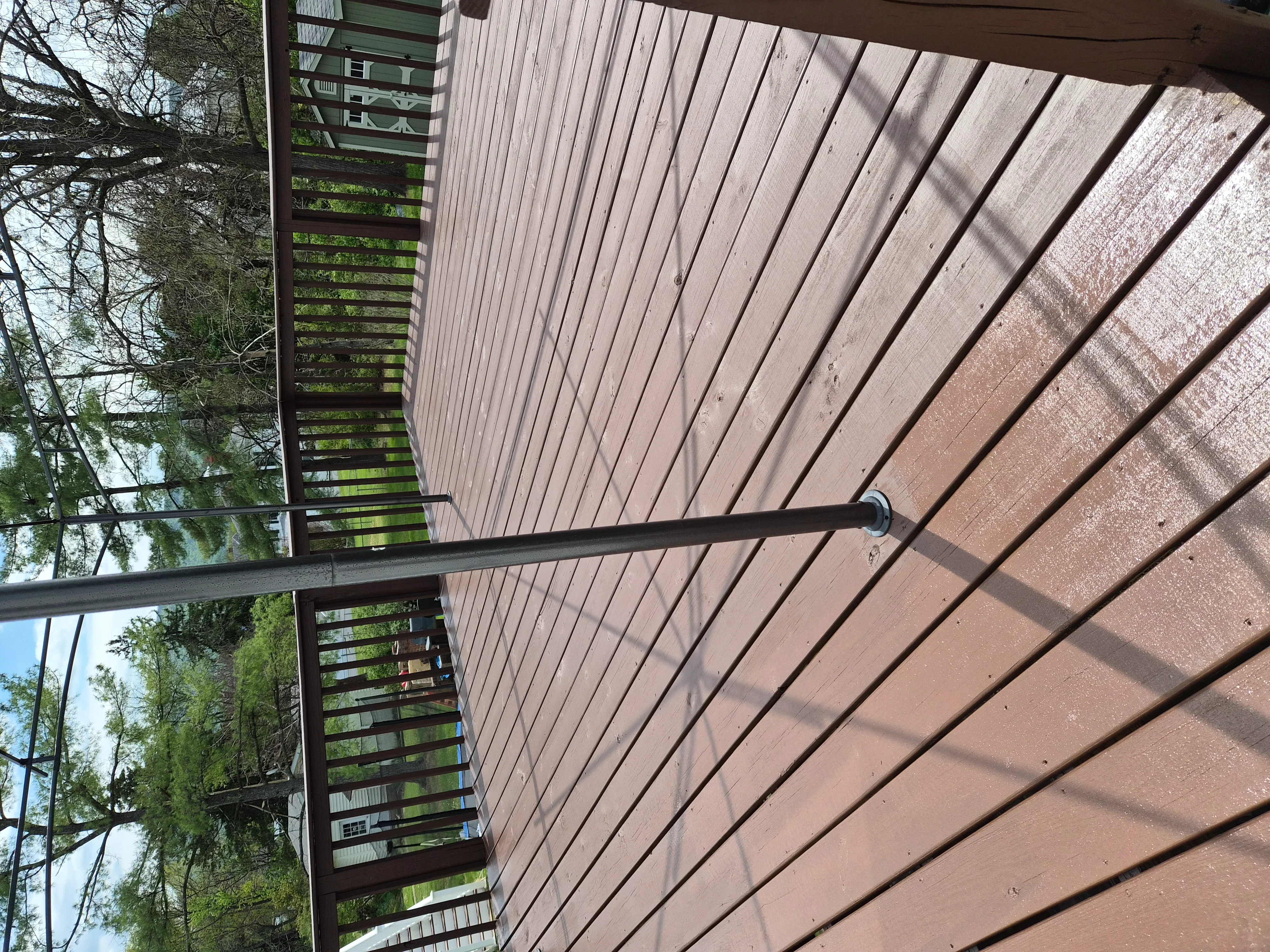 Composite deck with brown stain and horizontal metal railing with dark frame
