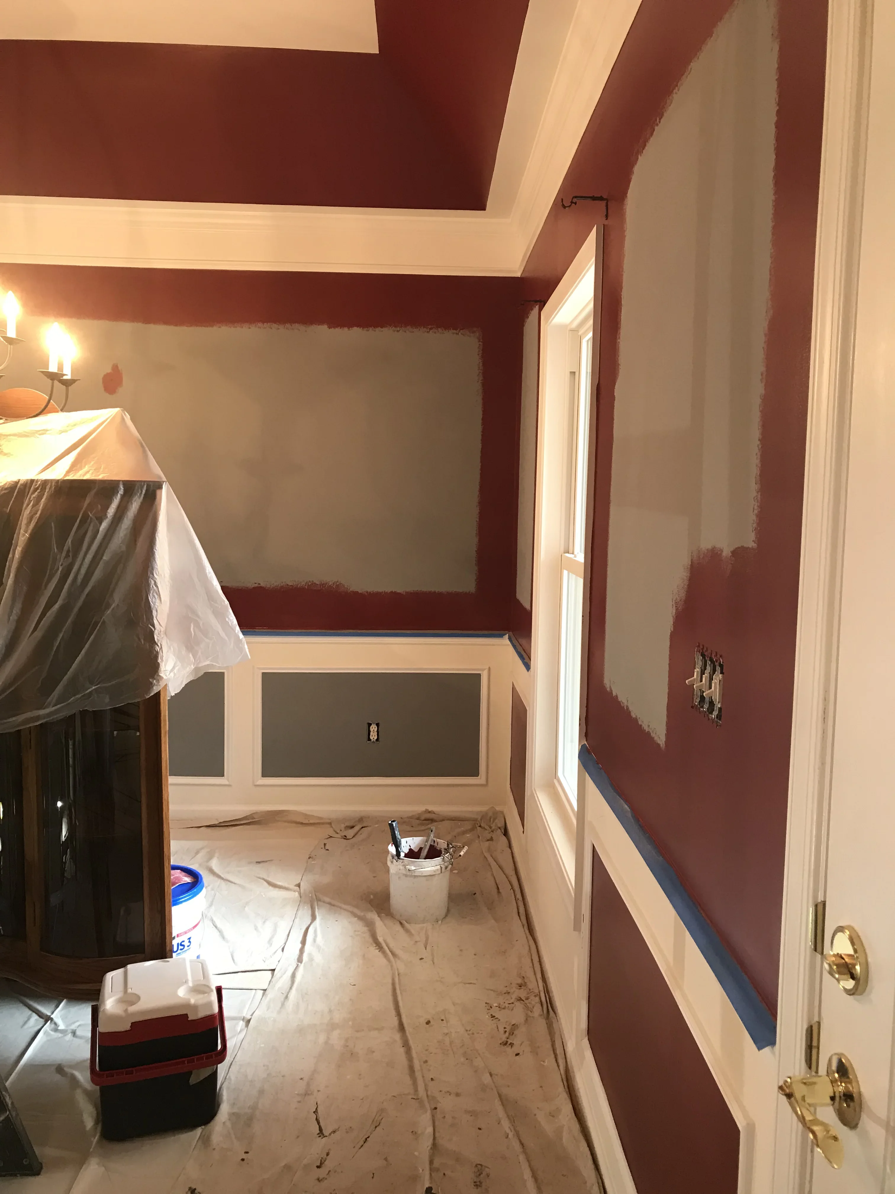 Bedroom interior with burgundy and cream two-tone paint, white trim, and coffered ceiling in progress