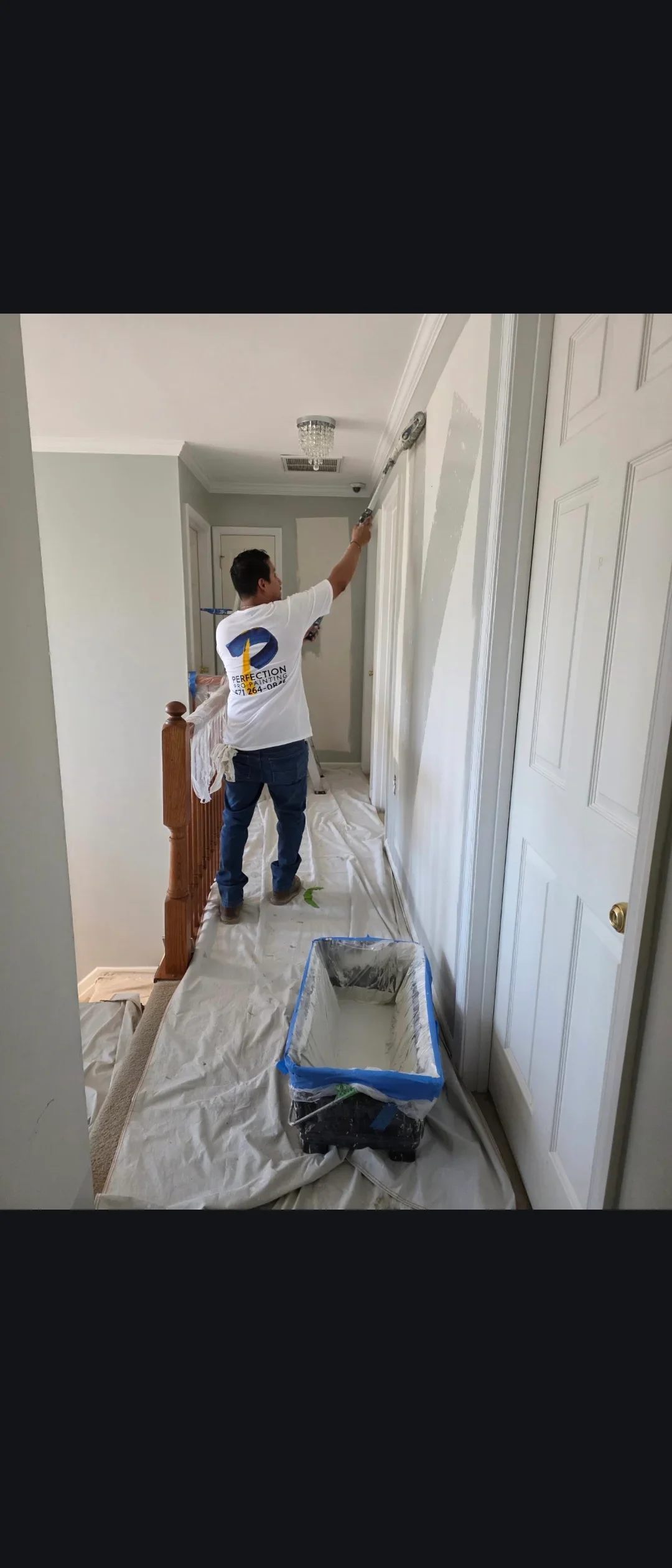 Interior hallway with white painted walls, ceiling, and six-panel doors during painting project