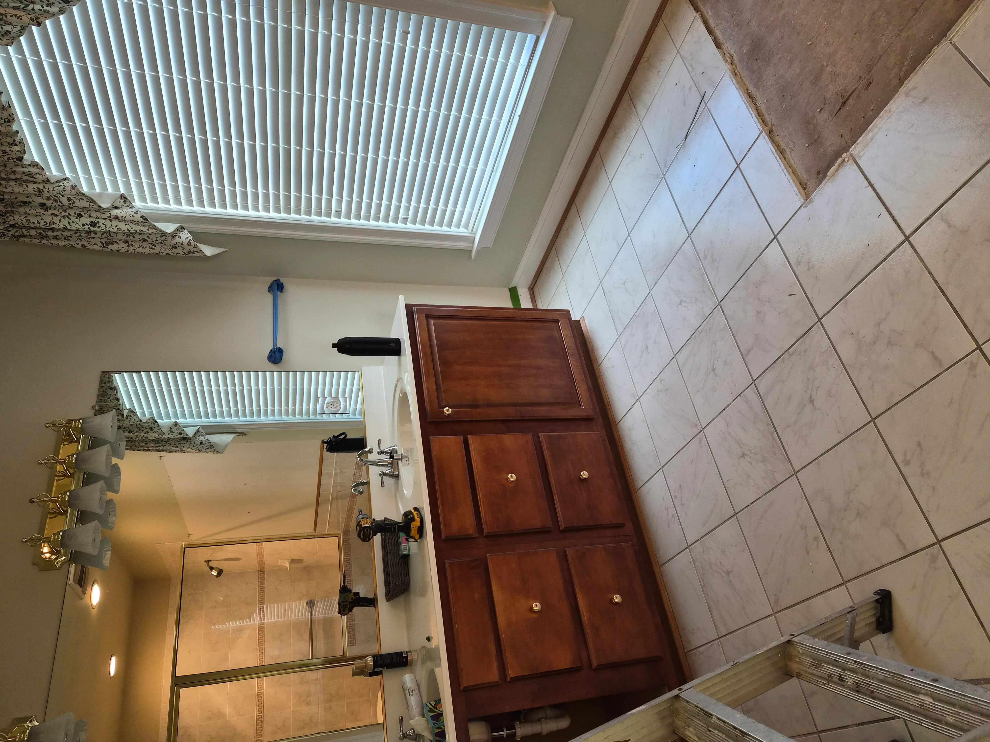 Bathroom with painted walls, vertical blinds, wood cabinetry, and ceramic tile flooring