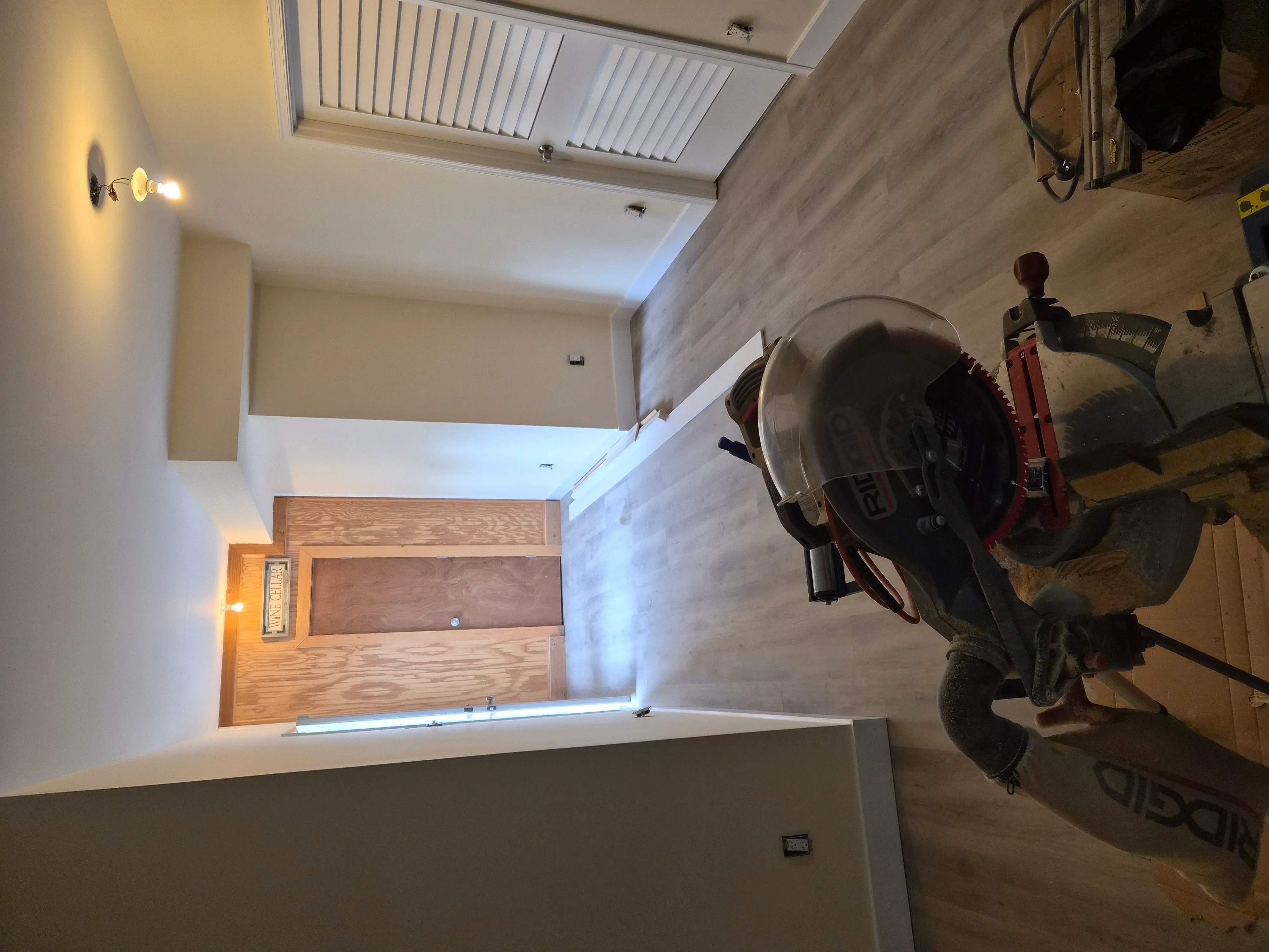 Painted drywall walls, wood-trimmed doorway, recessed and accent lighting installation