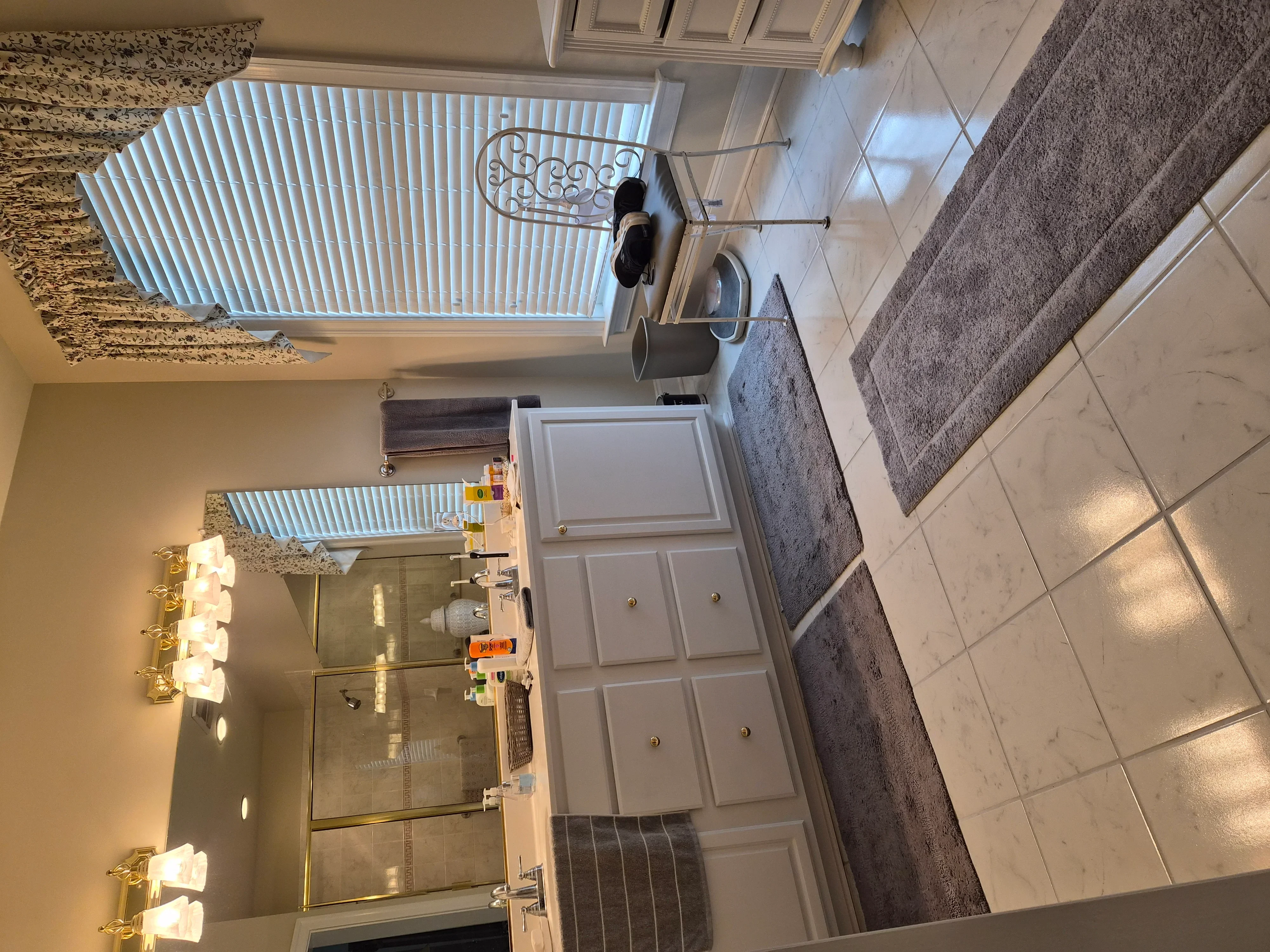 Painted bathroom with white cabinets, granite counters, tile flooring, and glass shower enclosure