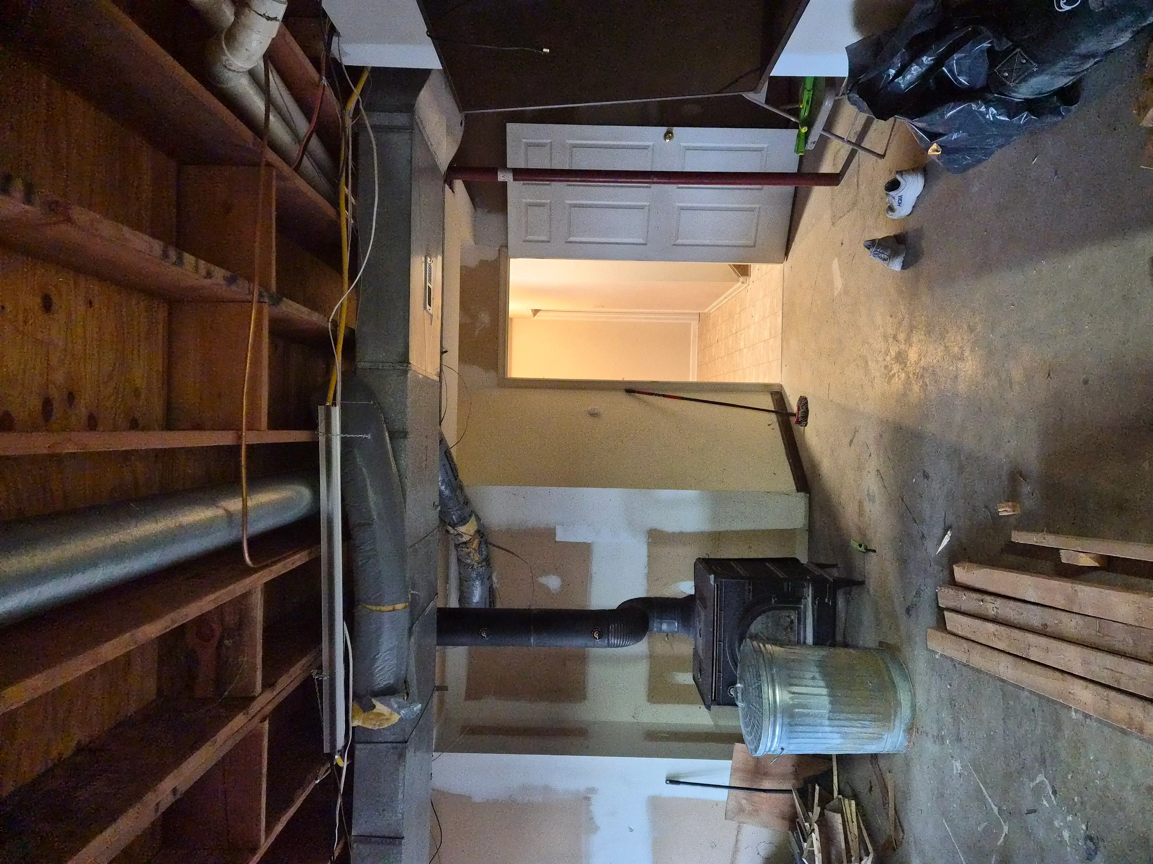 Interior room with drywall installation, primer coating on walls and ceiling, white garage door