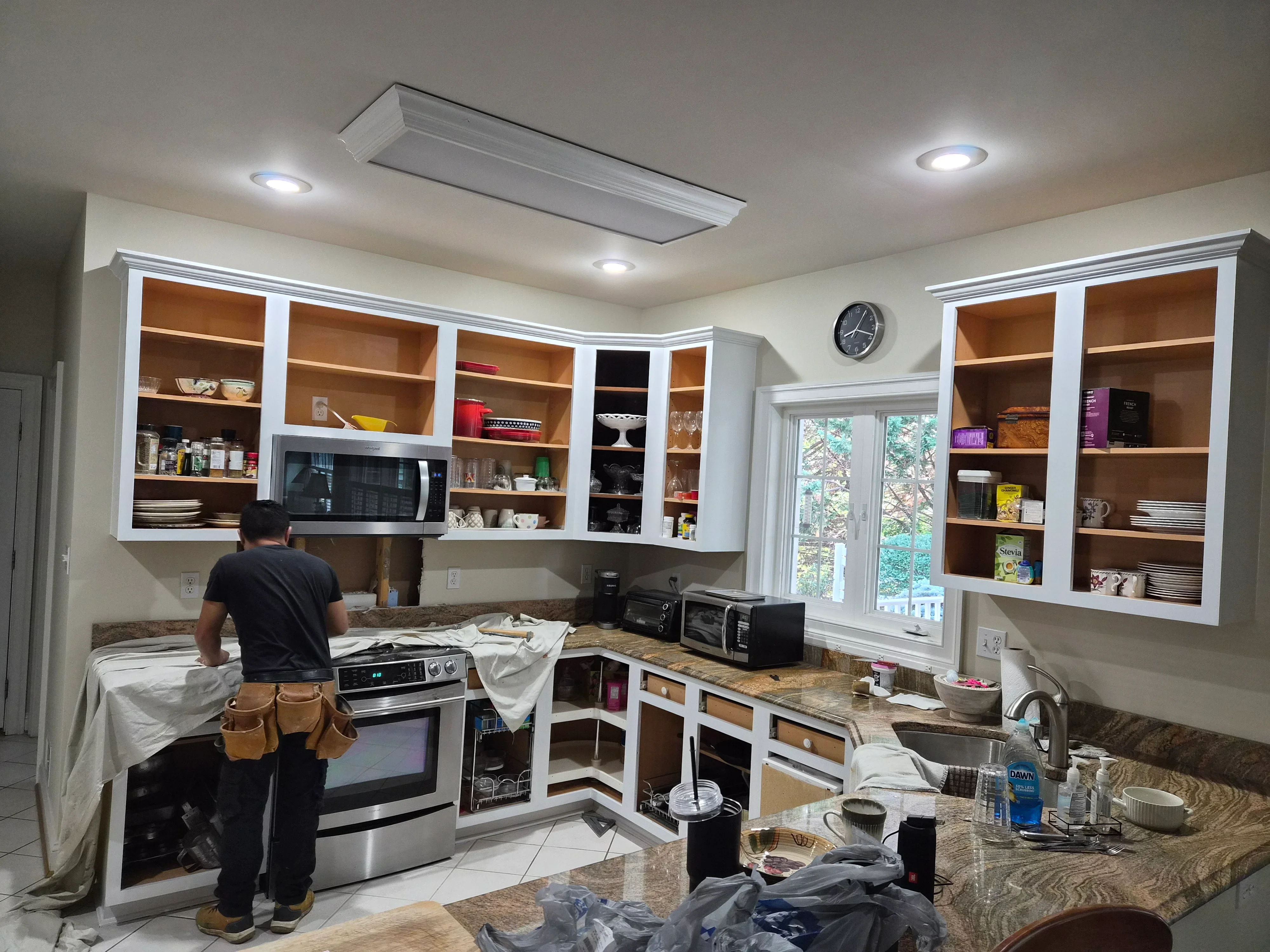 White painted kitchen cabinets with wood interiors, painted ceiling with recessed lights, granite countertops