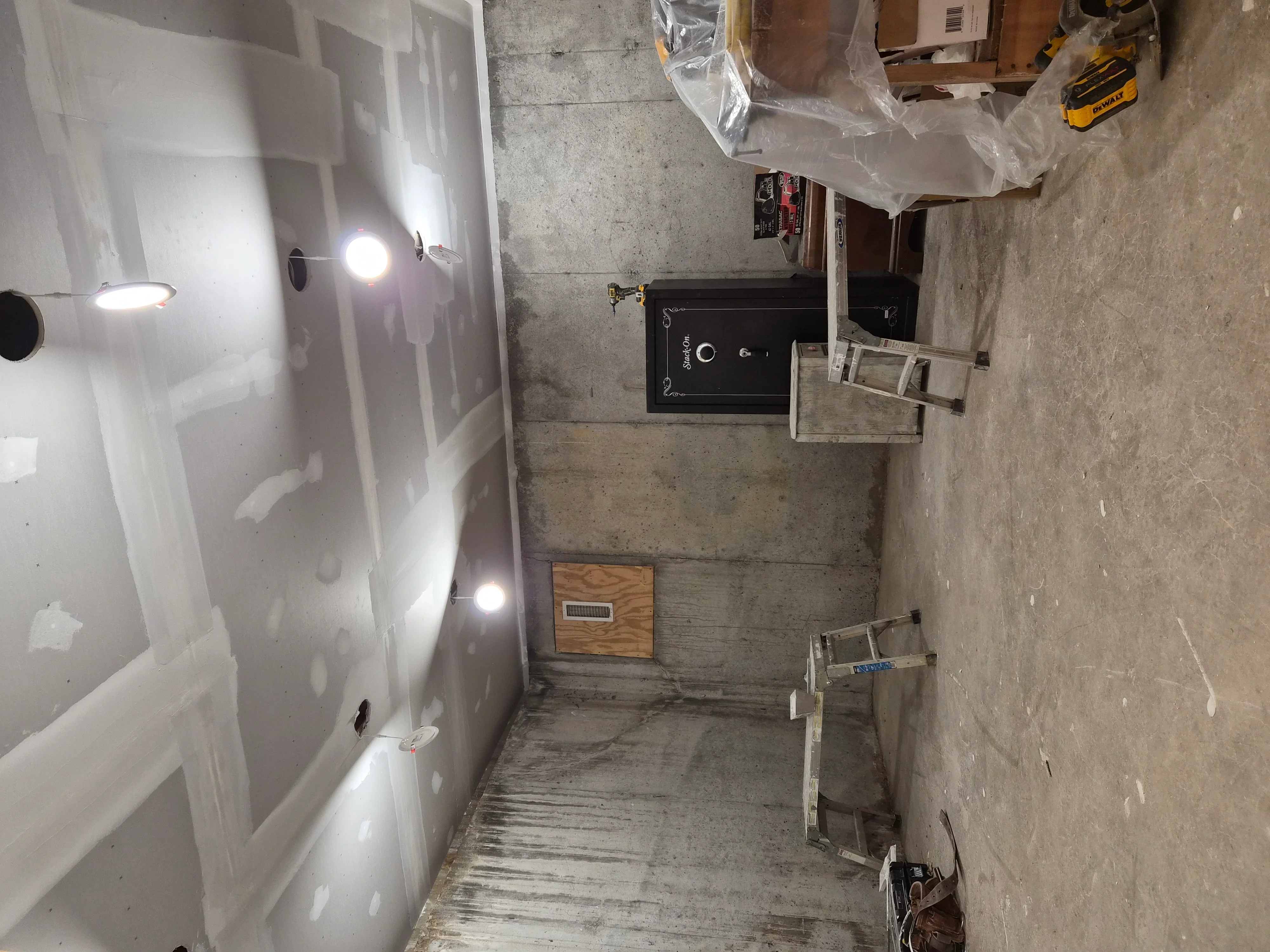 Bathroom with drywall installation, recessed lighting, and primed walls ready for painting