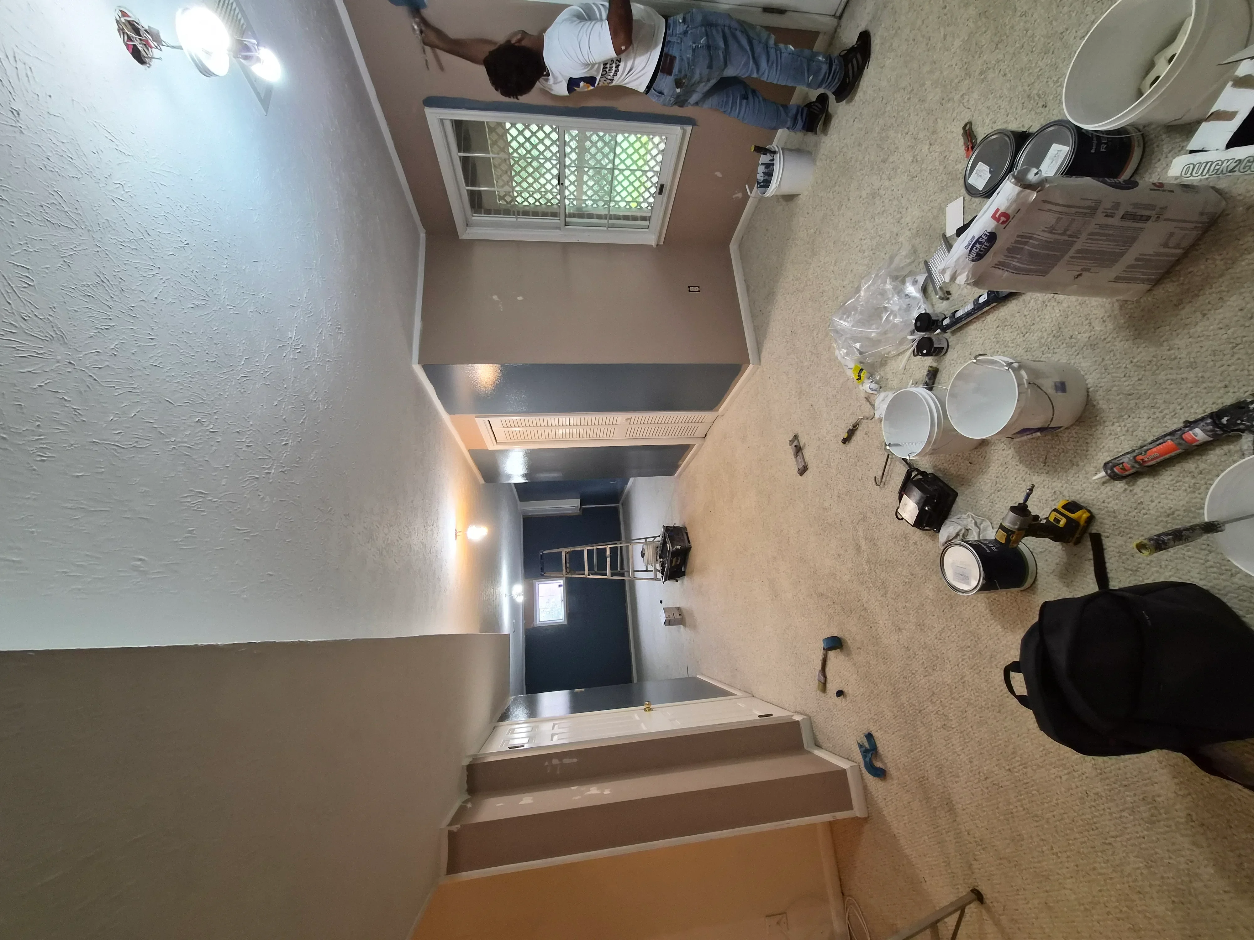 Stairwell and hallway with freshly painted walls, textured drywall, and trim in neutral colors