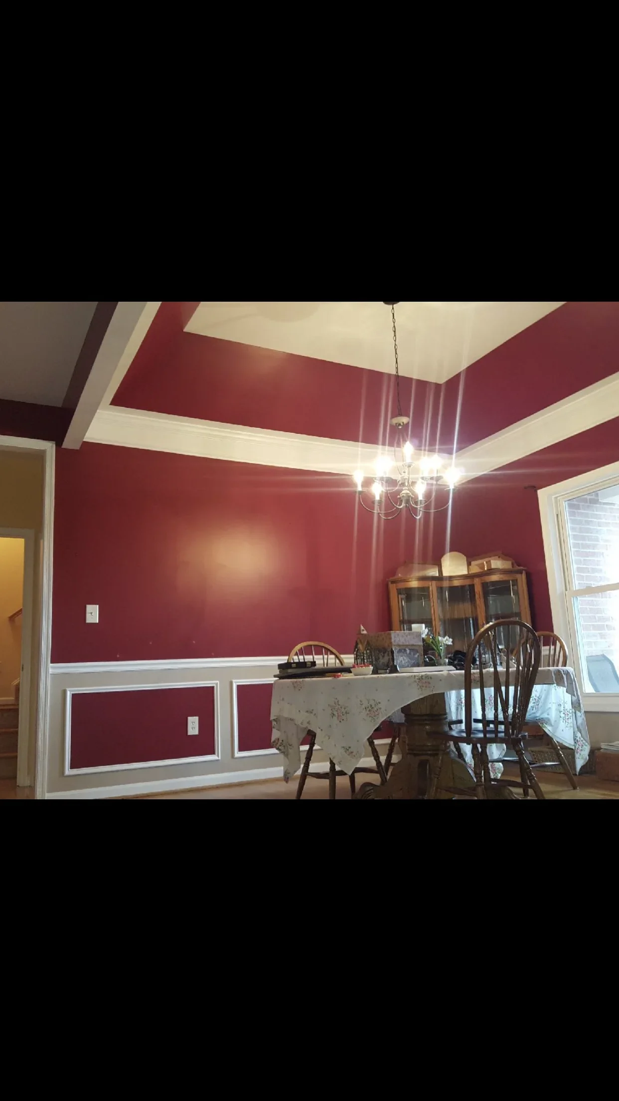 Burgundy and white painted dining room with coffered ceiling and wainscoting trim