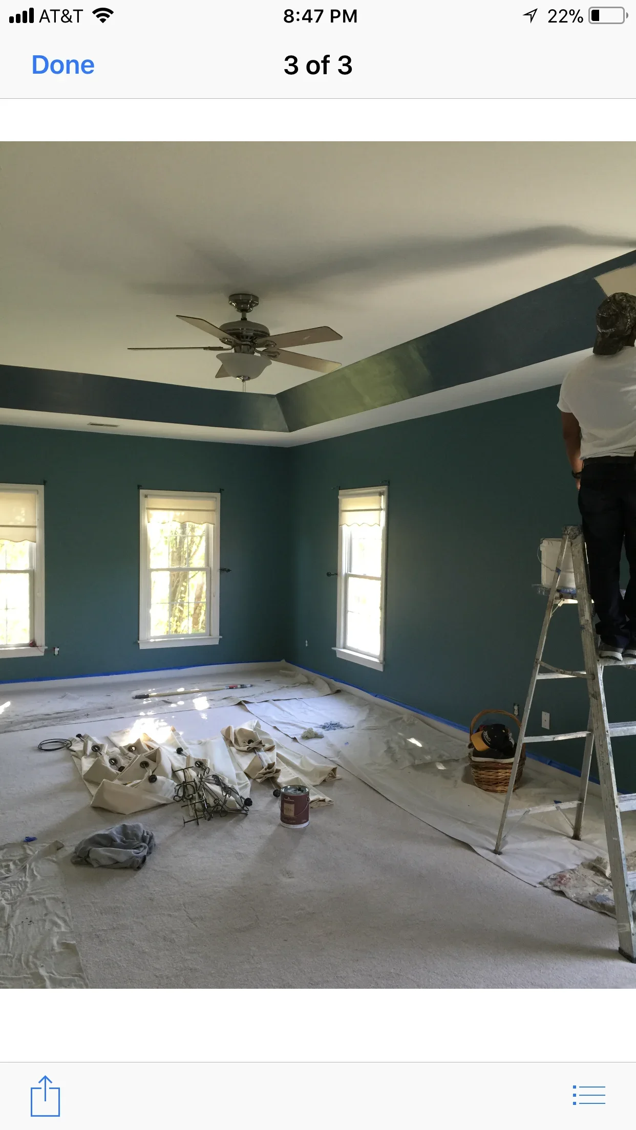 Teal painted walls with white and dark teal coffered ceiling, ceiling fan, and trim work