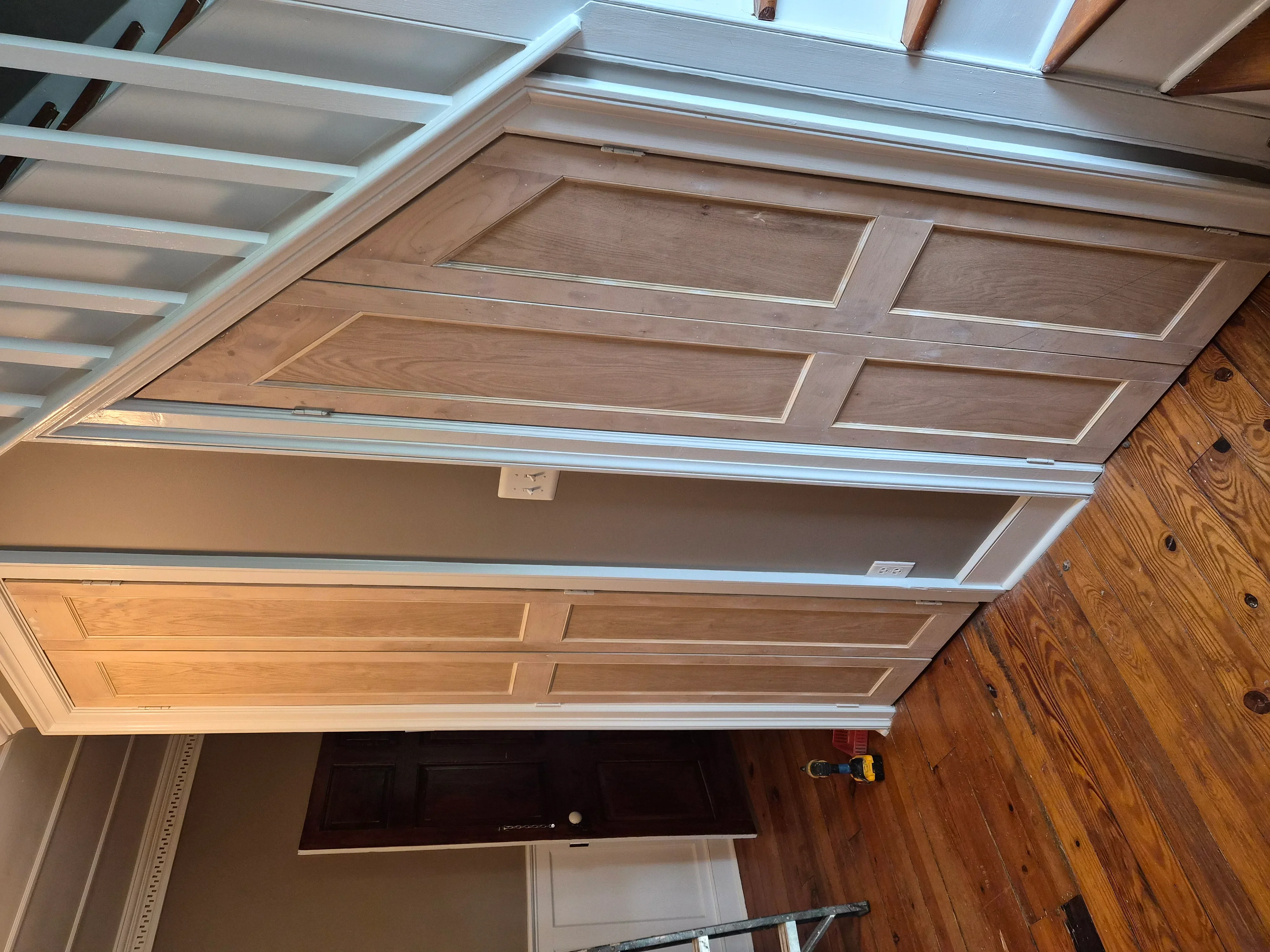 Two-tone painted garage door with raised panels and white-trimmed coffered ceiling with gray panels