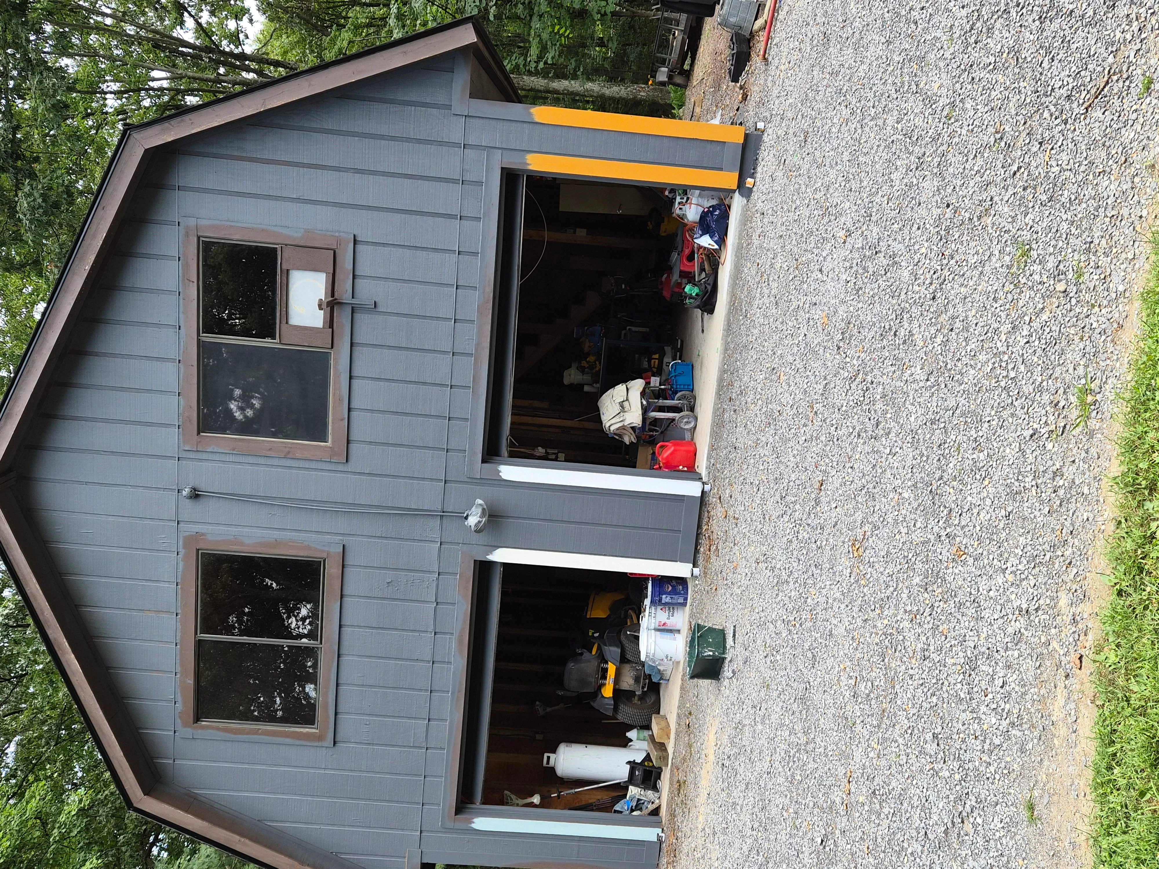 Gray painted garage exterior with brown-trimmed windows and freshly painted garage doors
