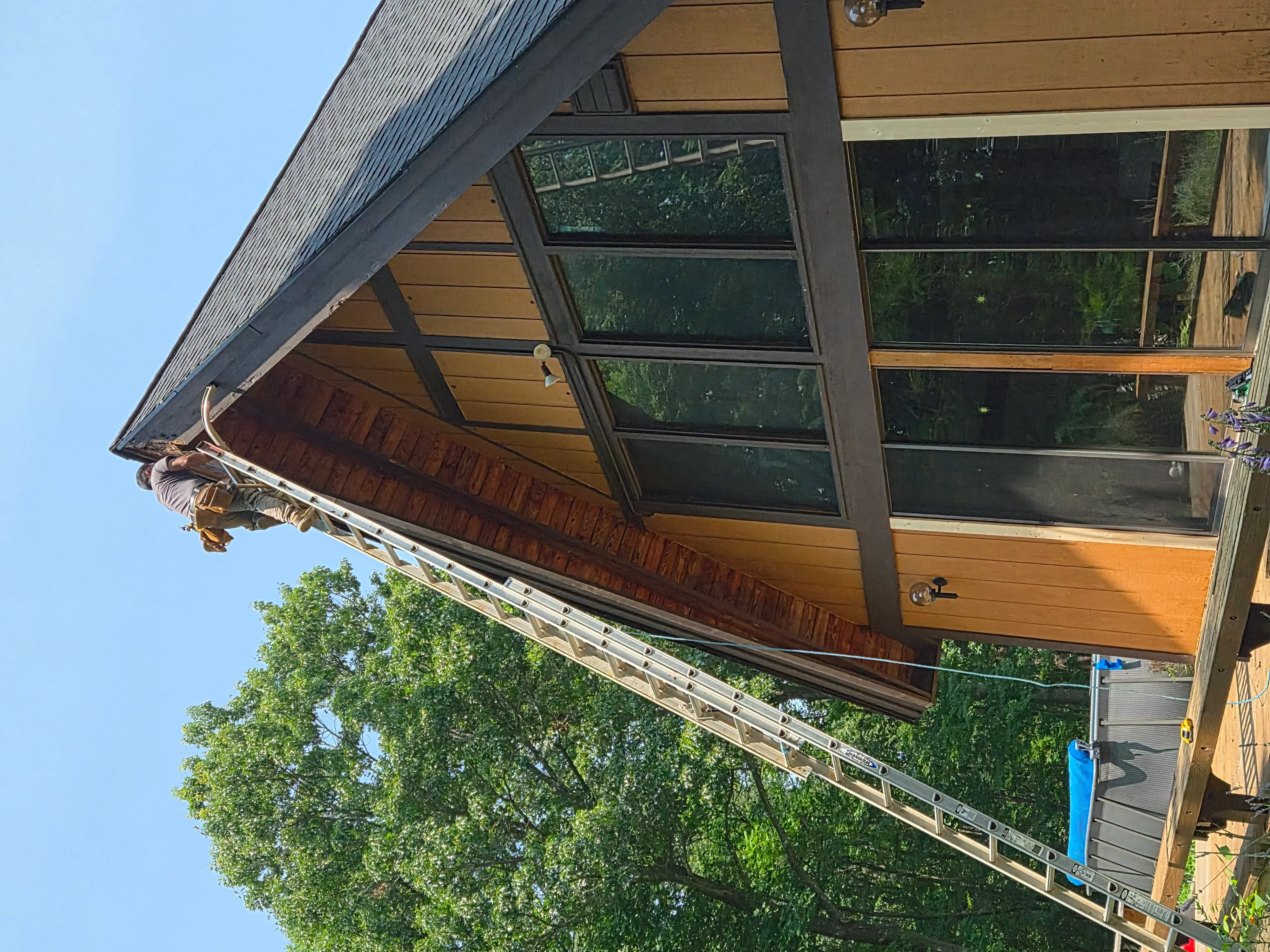 Glass garage door with black frame on wood-sided home exterior