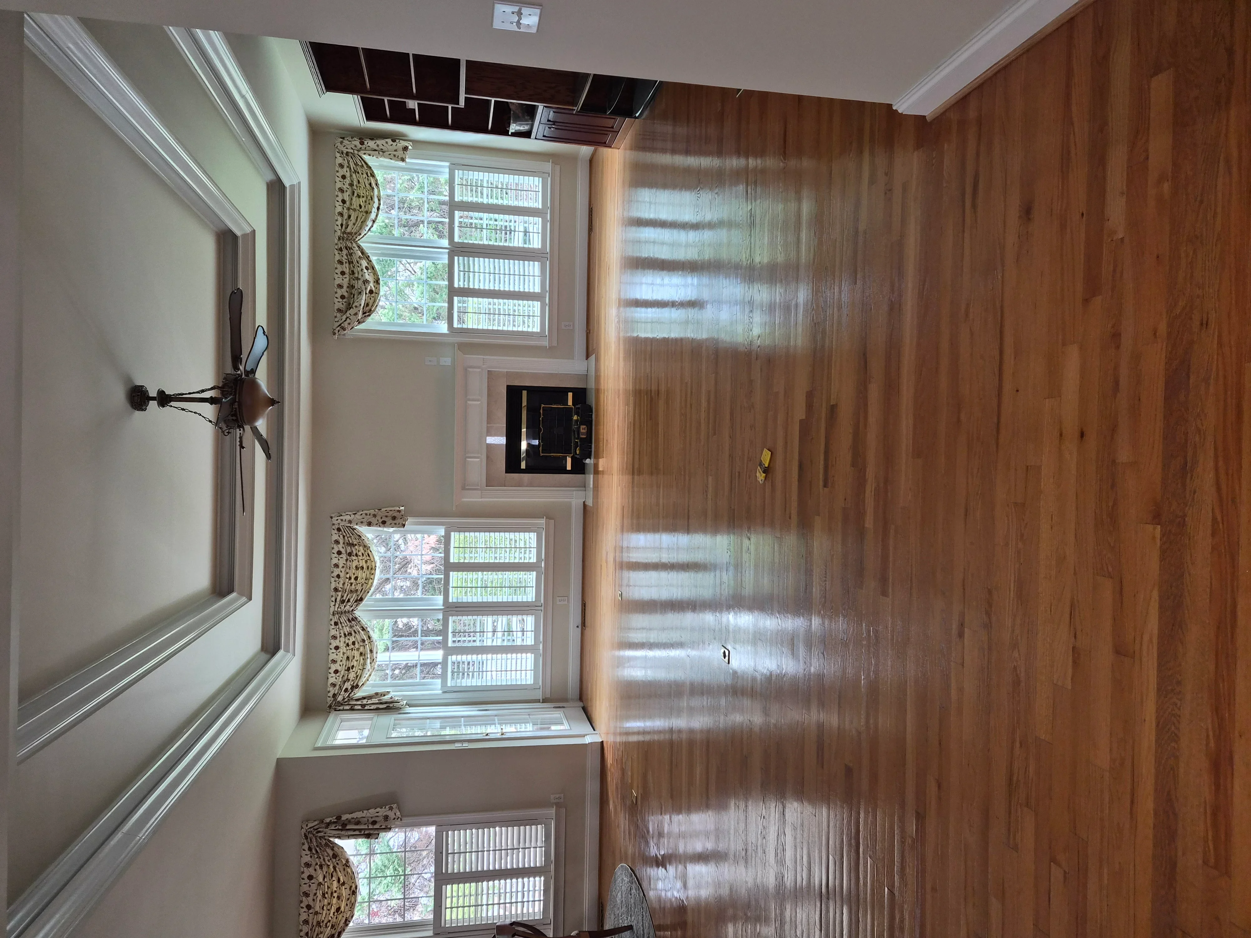White painted walls and crown molding with wood flooring and trim carpentry