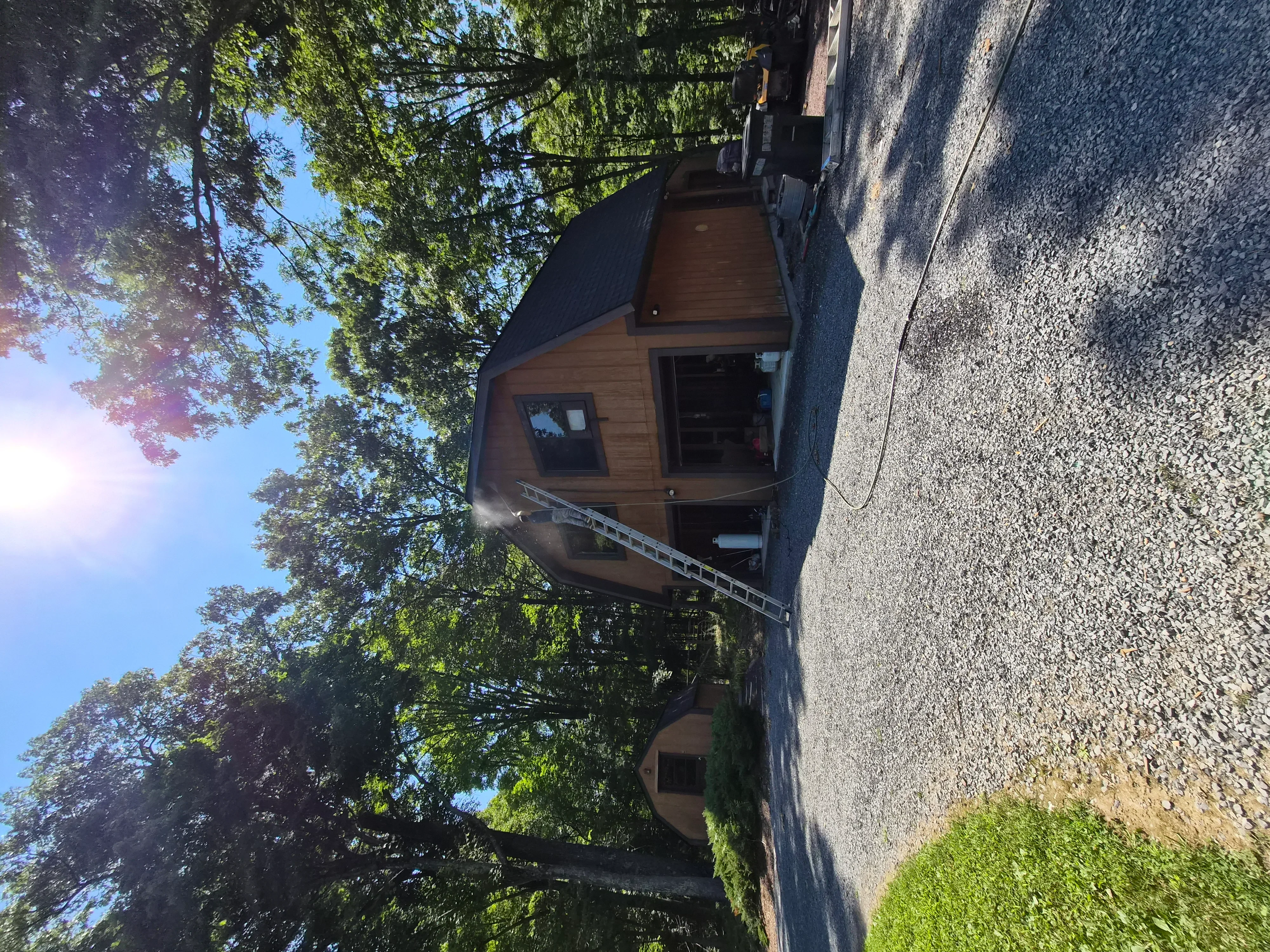 Brown painted cedar shake siding on residential home with stone chimney and dark roof