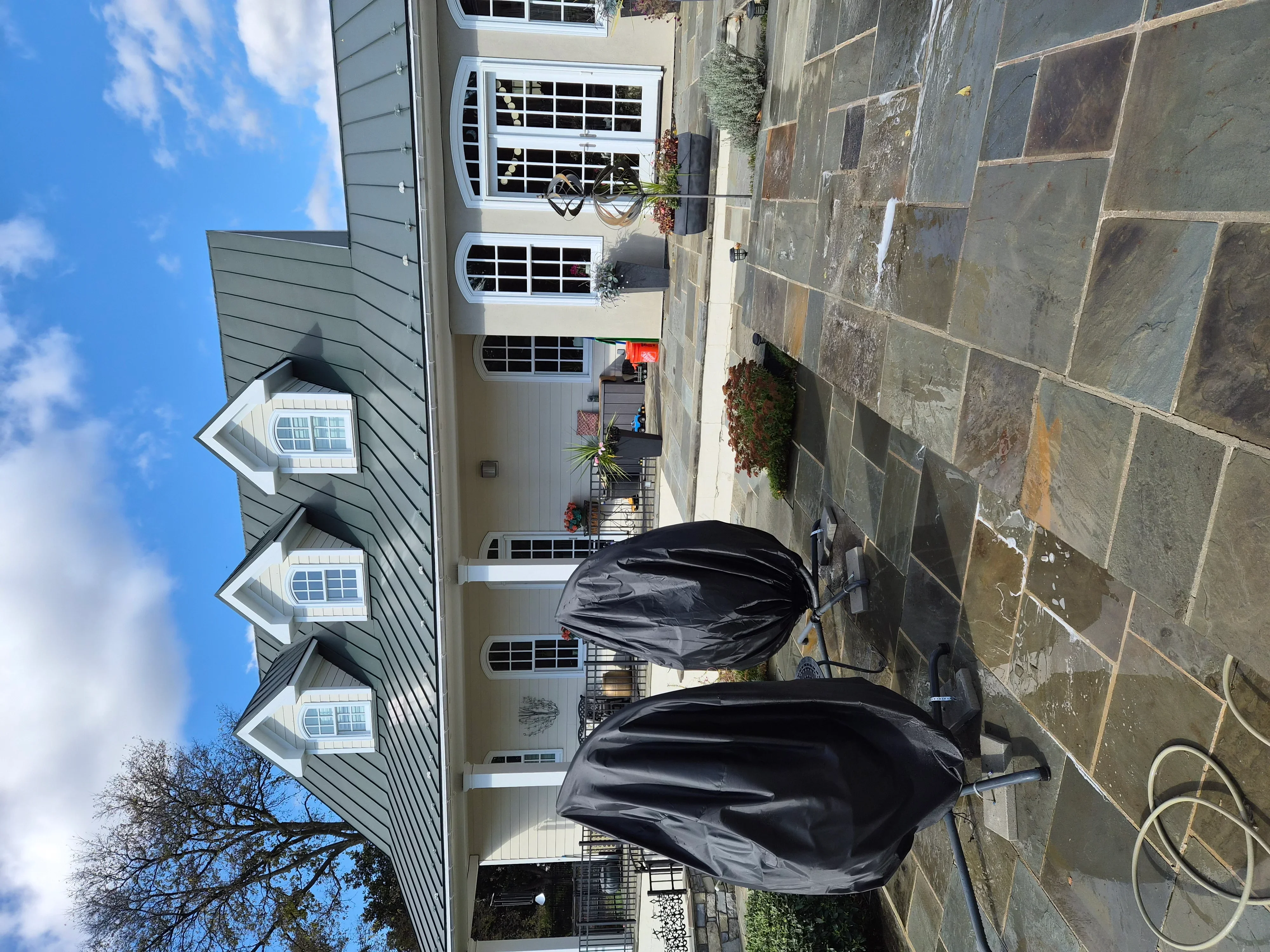 Gray fiber cement siding with black garage doors and white trim on residential exterior