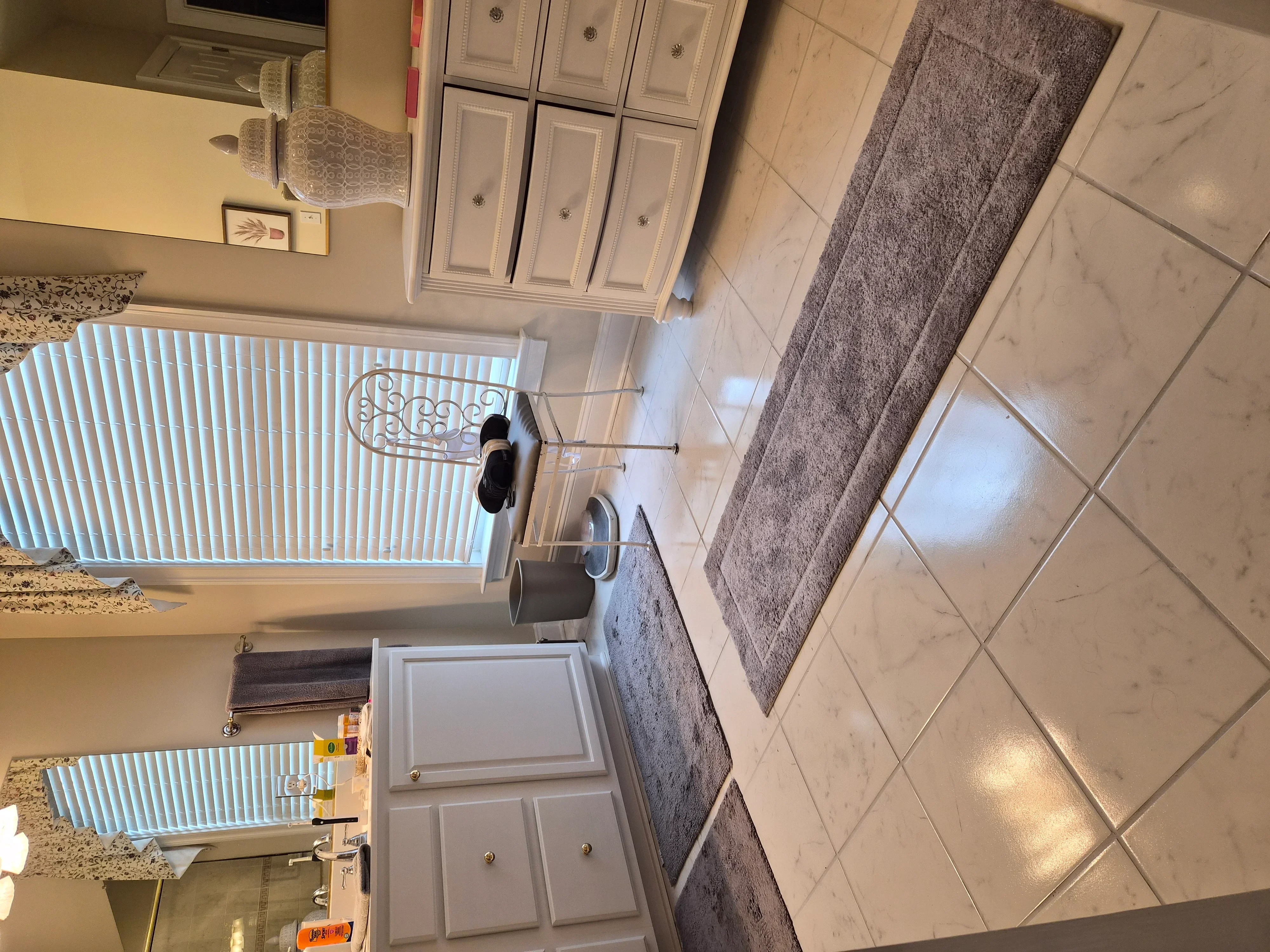 White painted kitchen cabinets with raised-panel doors and painted trim in bright kitchen space