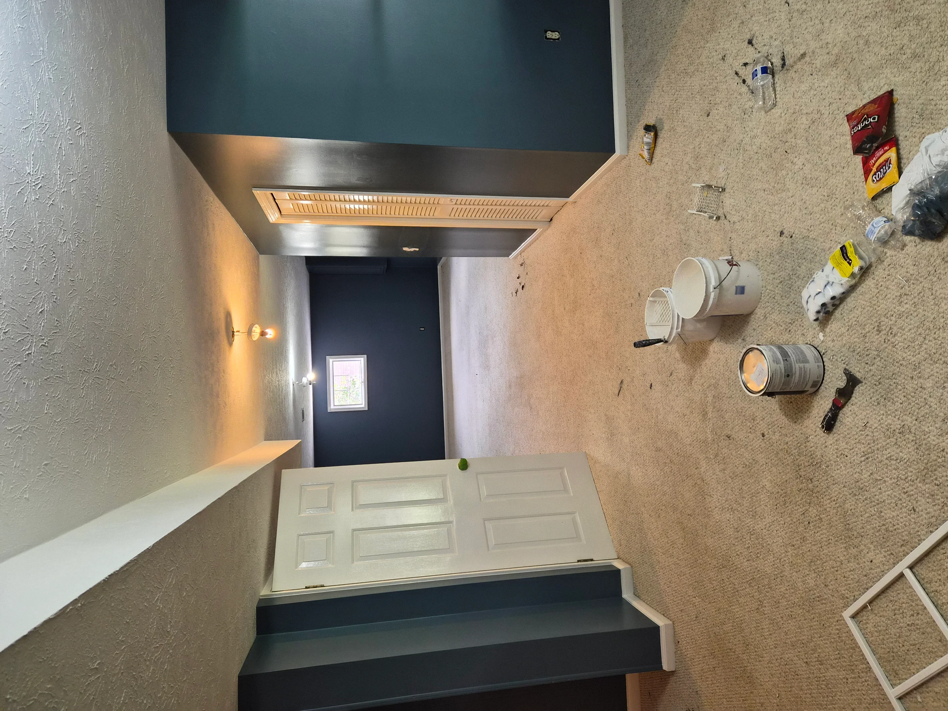 Hallway with textured walls, dark teal ceiling, white trim, and exhaust hood installation